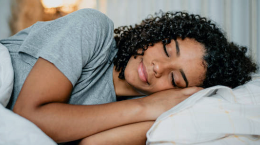 Woman sleeping peacefully with glowing, healthy skin representing nighttime skin repair and cellular regeneration