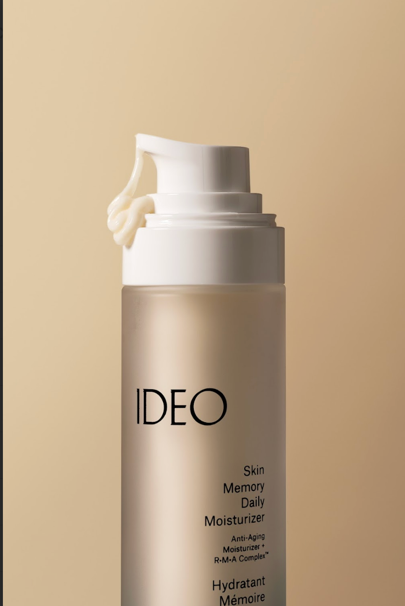 IDEO Skin Memory Daily Moisturizer pump bottle dispensing cream on warm beige background close-up product shot