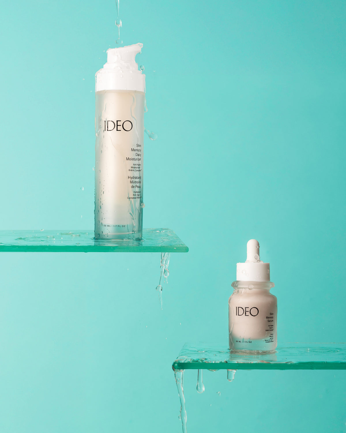 IDEO Skin Memory Daily Moisturizer and Skin Memory Serum on wet glass shelves against a turquoise background
